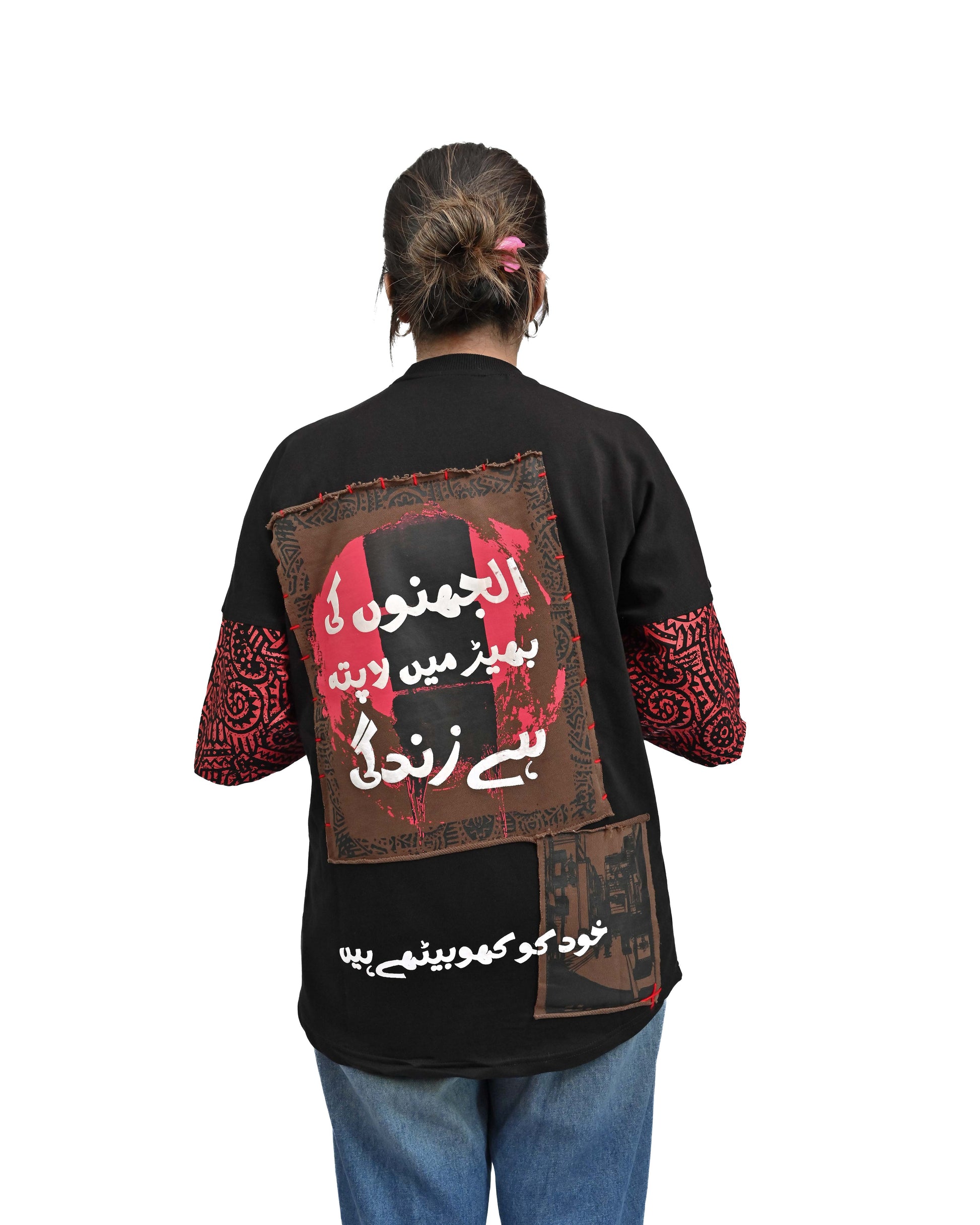 Person wearing "Lost in Grief" a Cream And Black graphic t-shirt with text on the back, standing against a white background made in pakistan