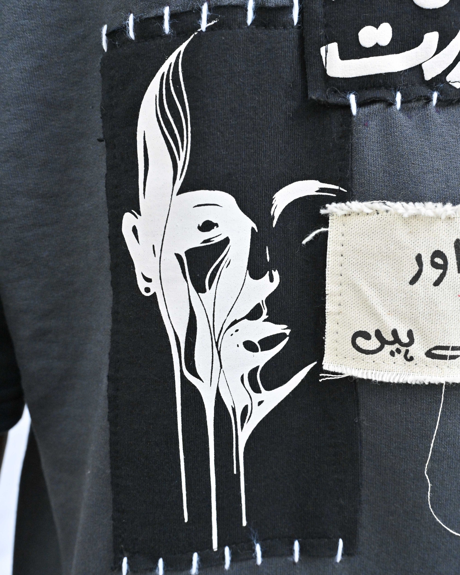 Person wearing "Chronicle" a white And Black graphic t-shirt with text on the back, standing against a white background made in pakistan