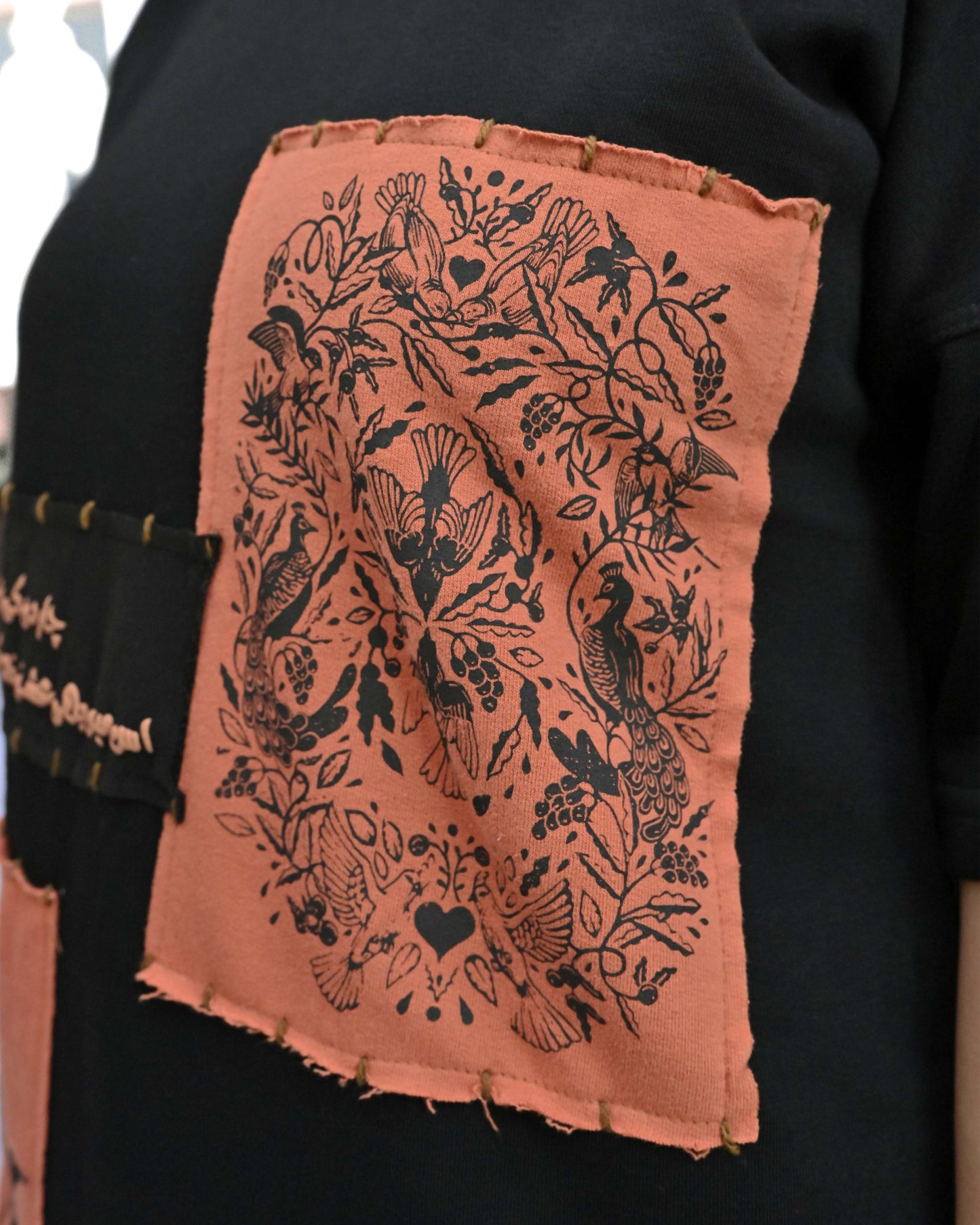 Person wearing "Vese in Stone" a Cream And Black graphic t-shirt with text on the back, standing against a white background made in pakistan