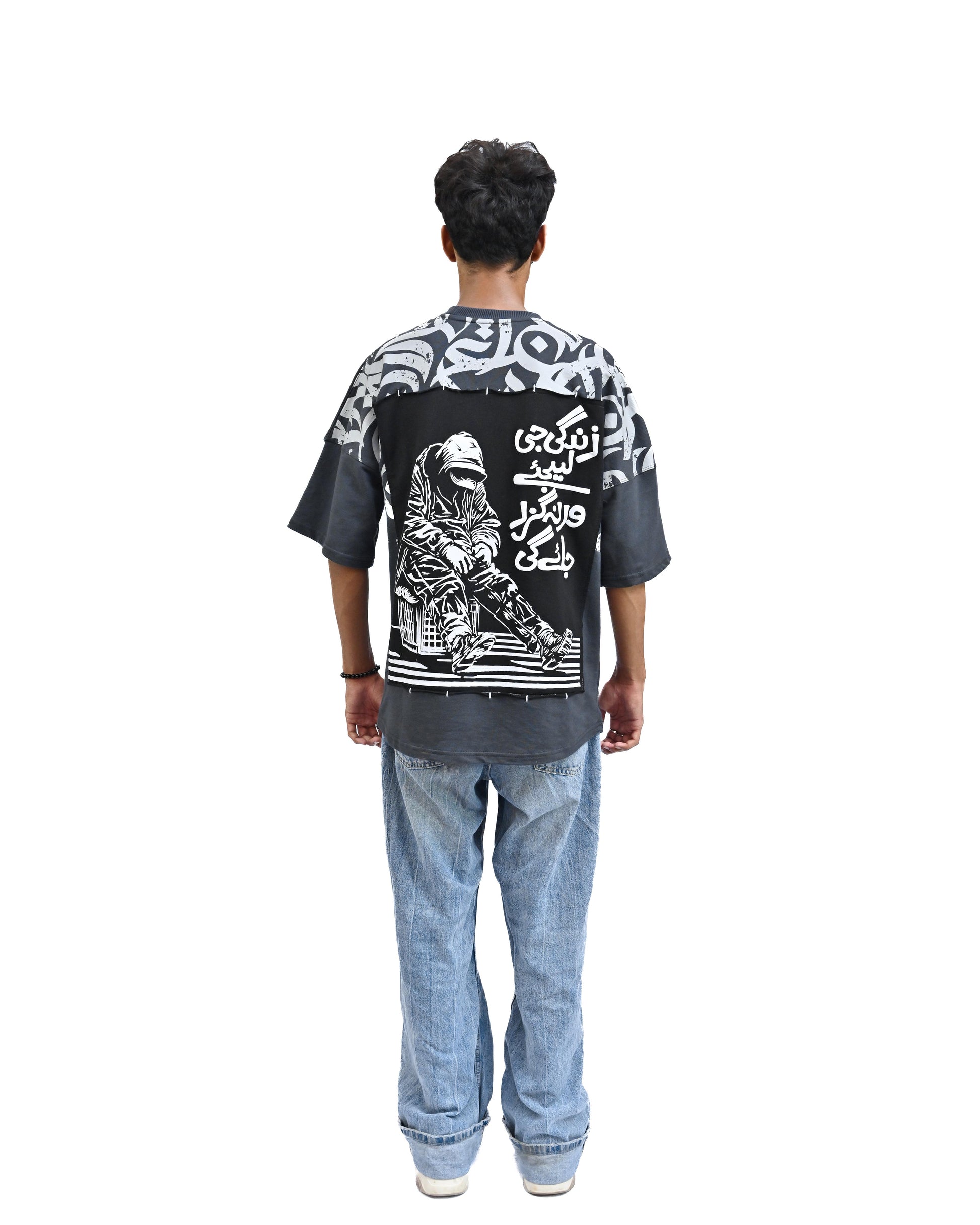 Person wearing "Stone & Spirit" a black and white graphic t-shirt with text on the back, standing against a white background.