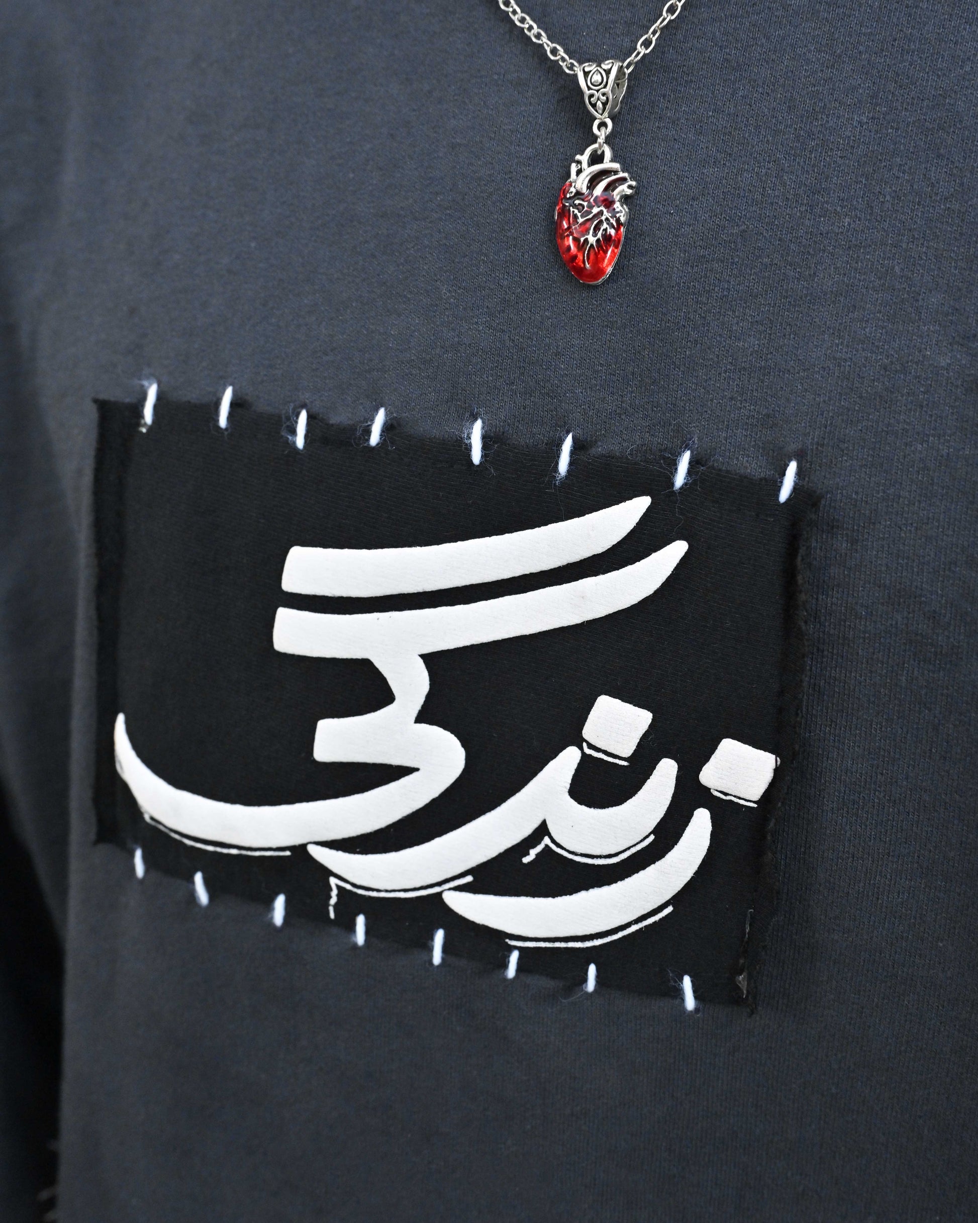 Person wearing "Stone & Spirit" a black and white graphic t-shirt with text on the back, standing against a white background.