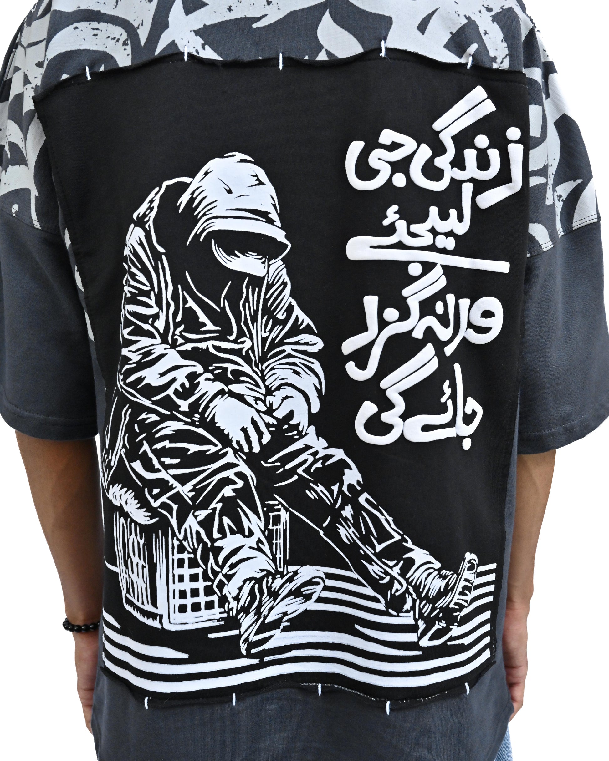 Two people wearing matching black t-shirts with white designs, standing back-to-back on a white background.