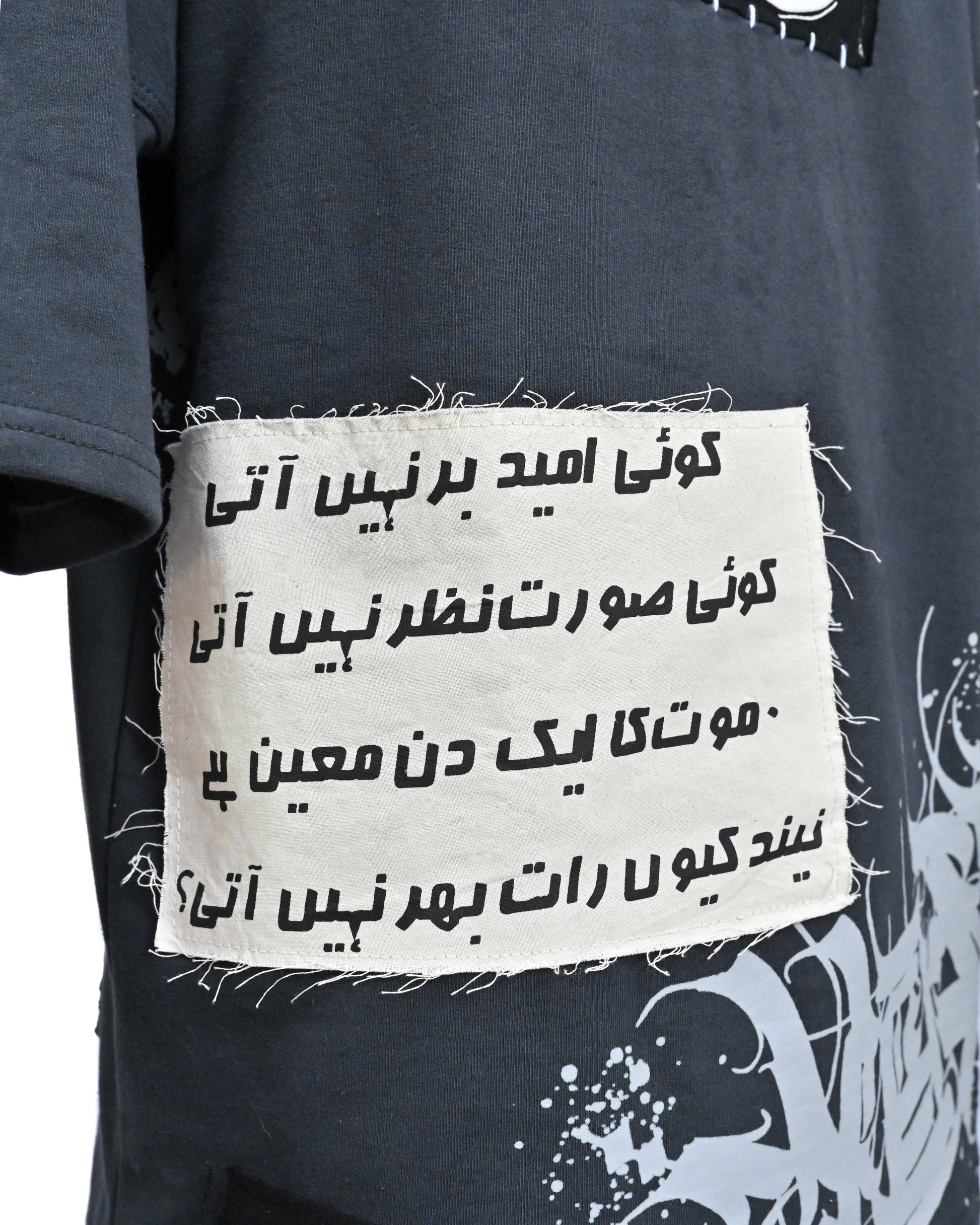 Person wearing "Stone & Spirit" a black and white graphic t-shirt with text on the back, standing against a white background.