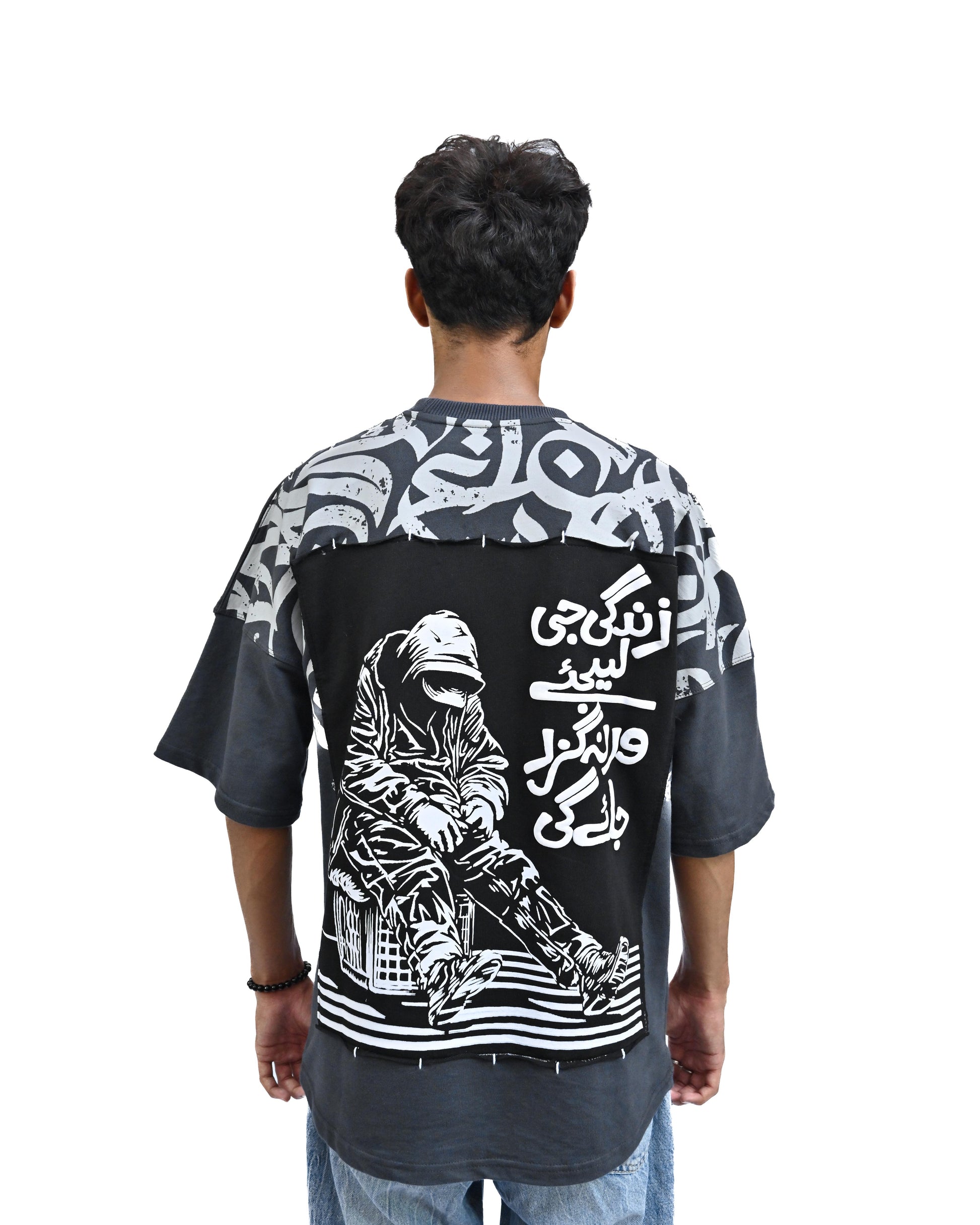 Person wearing "Stone & Spirit" a black and white graphic t-shirt with text on the back, standing against a white background.