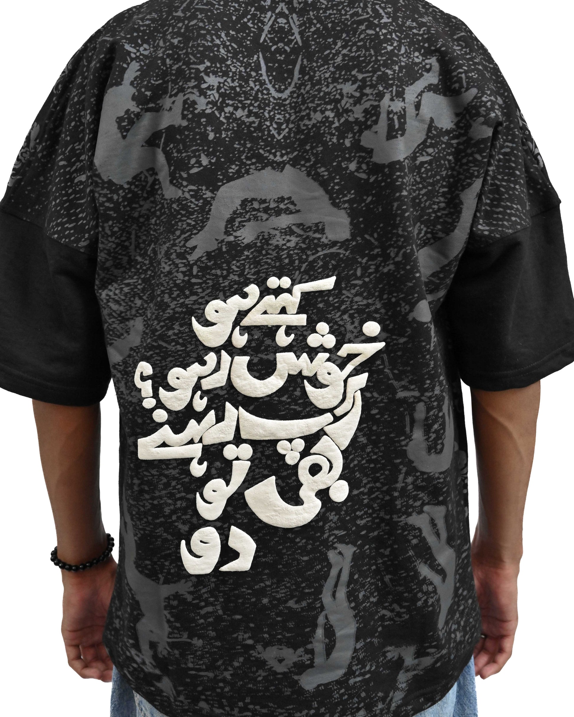 Person wearing "Black Verse" a white And Black graphic t-shirt with text on the back, standing against a white background made in pakistan